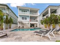 Gorgeous two-story home featuring a private backyard pool and spa with elegant stone patio at 371 12Th Ave, Indian Rocks Beach, FL 33785