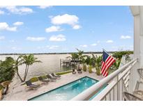 Inviting pool area with waterfront view, lounge chairs, and lush landscaping create a private oasis at 371 12Th Ave, Indian Rocks Beach, FL 33785