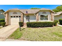 Charming single-story home with brick accents, manicured lawn, and an attached garage at 4740 Carrington Ct # 4740, New Port Richey, FL 34655