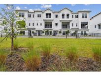 Beautiful three-story townhomes with black metal railings and a well-manicured lawn at 7232 Sutton Ln, Sarasota, FL 34240