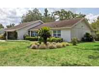 Well-maintained single-story home with a beautiful lawn and manicured landscaping around the exterior at 805 Bannockburn Ave, Temple Terrace, FL 33617