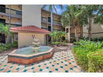 Exterior shot of building with landscaping featuring a three-tiered fountain at 2400 Feather Sound Dr # 1136, Clearwater, FL 33762