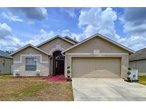 Inviting single Gathering home with a well-manicured lawn and two-car garage on a sunny day at 24305 Denali Ct, Lutz, FL 33559