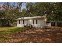 Charming single-story home with a white exterior, black shutters, and a metal roof at 4522 5Th St, Zephyrhills, FL 33542
