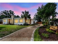 A well-maintained home with a stone chimney, garden beds and a gravel driveway at 4560 7Th N Ave, St Petersburg, FL 33713