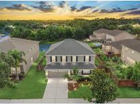 Two-story home boasts a manicured lawn, a two-car garage, and mature trees in a desirable community at 5804 Butterfield St, Riverview, FL 33578