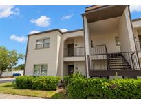 Two-story condo building exterior with landscaped bushes and entryways at 7701 Starkey Rd # 332, Seminole, FL 33777
