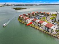 Waterfront condominiums with red tile roofs are nestled along the tranquil bay, offering scenic views and convenient parking at 868 Bayway Blvd # 206, Clearwater Beach, FL 33767