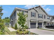 Stylish townhome featuring neutral siding, dark shutters, and attached single-car garage at 9665 Sweetwell Pl, Riverview, FL 33569