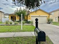 Charming single-story home with a well-manicured lawn and a two car garage on a sunny day at 10607 Boyette Creek Blvd, Riverview, FL 33569