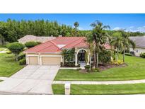 Beautiful home showcasing a well-manicured lawn, lovely landscaping, and a three-car garage at 19107 Avenue Bayonnes, Lutz, FL 33558