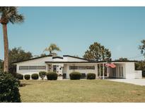 Charming single-story home featuring a well-maintained lawn, trimmed hedges, and a quaint covered porch area at 1980 Forked Creek Dr, Englewood, FL 34223