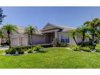 Charming single-story home features a well-manicured lawn and lush landscaping with swaying palm trees at 2220 Elizabeth Way, Dunedin, FL 34698