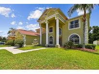 Inviting front exterior with large pillars, well-manicured lawn, and a decorative water fountain feature at 27012 Sea Breeze Way, Wesley Chapel, FL 33544