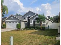 Charming single-story home with a well-manicured lawn and beautiful landscaping under a bright, cloudy sky at 29228 Yarrow Dr, Wesley Chapel, FL 33543