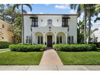 Beautiful white stucco two-story home with arched porch, tile roof, lush landscaping and brick walkway at 3212 W Fountain Blvd, Tampa, FL 33609