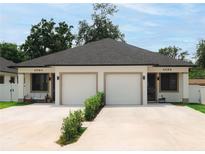 Charming duplex featuring a modern design, well-manicured landscaping, and individual one-car garages at 4108 N Thatcher, Tampa, FL 33614