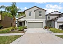 Two story home with a two car garage, beautiful landscaping and a palm tree in the front yard at 4533 Eternal Prince Dr, Sun City Center, FL 33573