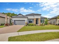 Charming single-story home with well-manicured lawn, stone accents, tile roof, and paver driveway at 4831 Rosatti Rd, Wesley Chapel, FL 33543