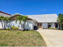 Charming single Gathering home featuring a stone facade and a well-maintained front yard with palm trees at 5012 Ensign Loop, New Port Richey, FL 34652
