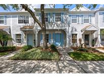 Inviting townhome with light blue shutters, beautiful landscaping, and a mature shade tree at 8612 Hunters Key Cir, Tampa, FL 33647