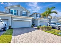 Charming townhomes showcasing brick driveways and well-manicured landscaping, under a beautiful sunny sky at 915 Tidewater Shores Loop, Bradenton, FL 34208