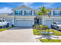 Charming townhome showcases a well-maintained exterior, lush landscaping, and inviting curb appeal under a sunny sky at 915 Tidewater Shores Loop, Bradenton, FL 34208