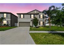 Charming two-story home features well-manicured landscaping, a spacious driveway, and a two-car garage at 13529 Wild Ginger St, Riverview, FL 33579