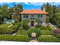 Elegant stucco home with a red tile roof and lush, mature landscaping at 136 W Davis Blvd, Tampa, FL 33606