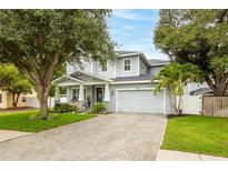 Beautiful two-story home with manicured lawn, paver driveway, and lush landscaping at 3611 W Royal Palm Cir, Tampa, FL 33629