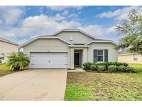 Charming single-story home with a well-manicured lawn and a two-car garage at 3876 Crossline Dr, Spring Hill, FL 34609