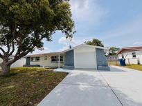 Charming single-story home with stone accents and a well-maintained front yard under a blue sky at 6046 7Th Ave, New Port Richey, FL 34653