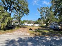 Image of land showing the lot for sale in a neighborhood with mature trees and grass at 658 15Th Nw St, Largo, FL 33770