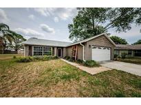 Charming single-story home with brick accents, attached garage, and a cozy landscaped front yard at 7763 Jenner Ave, New Port Richey, FL 34655