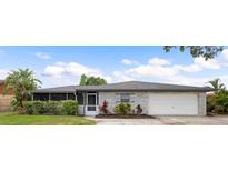 Charming single-story home with a two-car garage and a beautifully landscaped front yard on a sunny day at 916 Shangri La Dr, Seffner, FL 33584