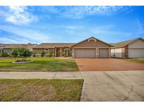 Charming single-story home featuring a three-car garage and beautifully manicured lawn at 1410 Monte Lake Dr, Valrico, FL 33596
