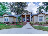 Charming single-story home featuring a well-manicured lawn, mature landscaping, and inviting column-supported front porch at 15302 Lake Maurine Dr, Odessa, FL 33556