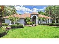 Stunning single-story home featuring a beautiful lawn, manicured landscaping, and a classic tile roof at 16343 Burniston Dr, Tampa, FL 33647