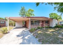 Charming single-story brick home featuring a carport and well-maintained front yard at 2003 Waikiki Way, Tampa, FL 33619