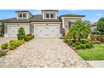 Beautiful home exterior with brick driveway, manicured landscaping, and a two-car garage at 4329 Barletta Ct, Wesley Chapel, FL 33543