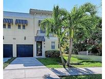 Charming two-story home featuring blue awnings, a private garage, and lush landscaping at 514 S Orleans Ave # 4, Tampa, FL 33606