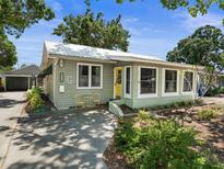 Charming single-story home with a yellow front door, lush landscaping, and an inviting curb appeal at 544 80Th N Ave, St Petersburg, FL 33702