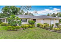 Charming single-story home featuring lush landscaping and attached two-car garage at 5456 Fairway Bend Dr, Sarasota, FL 34243