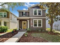 Charming two-story home featuring a bright yellow front door, manicured landscaping, and a welcoming walkway at 5914 Goldenbark Pl, Lithia, FL 33547