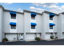 Charming townhome exterior with blue awnings, white trim and welcoming front entrances at 745 Pinellas Bayway S # 206, St Petersburg, FL 33715