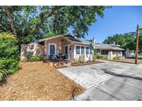 Charming bungalow with lush landscaping, brick driveway, and inviting front porch at 1174 8Th N St, St Petersburg, FL 33701