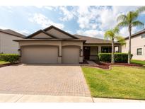 Charming one-story home featuring a paver driveway, two-car garage, and well-maintained landscaping at 12352 Crestridge Loop, New Port Richey, FL 34655