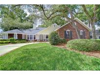 Charming brick and siding home with mature landscaping, lush green lawn, and inviting front porch at 124 Barrington Dr, Brandon, FL 33511