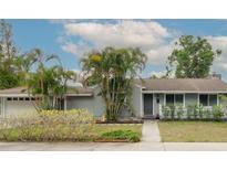 Charming single-story home with lush landscaping, including palm trees and a well-manicured lawn at 1722 48Th N Ave, St Petersburg, FL 33714