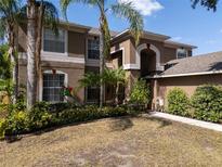Charming two-story home featuring stucco siding, complemented by lush landscaping and mature palm trees in the front yard at 4222 Trumpworth Ct, Valrico, FL 33596